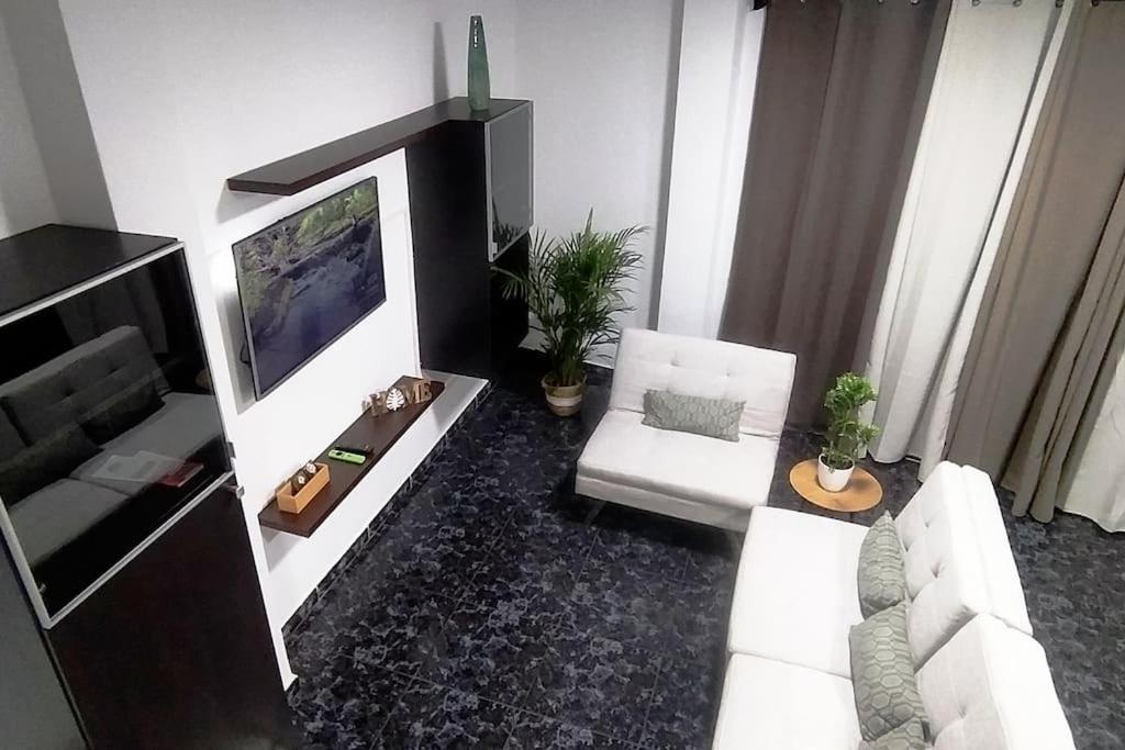 Il comprend un salon doté d'un canapé blanc et d'une télévision à écran plat. dans l'établissement CASA MARY, Céntrico y amplio piso cerca del mar, en Candelaria, à Candelaria