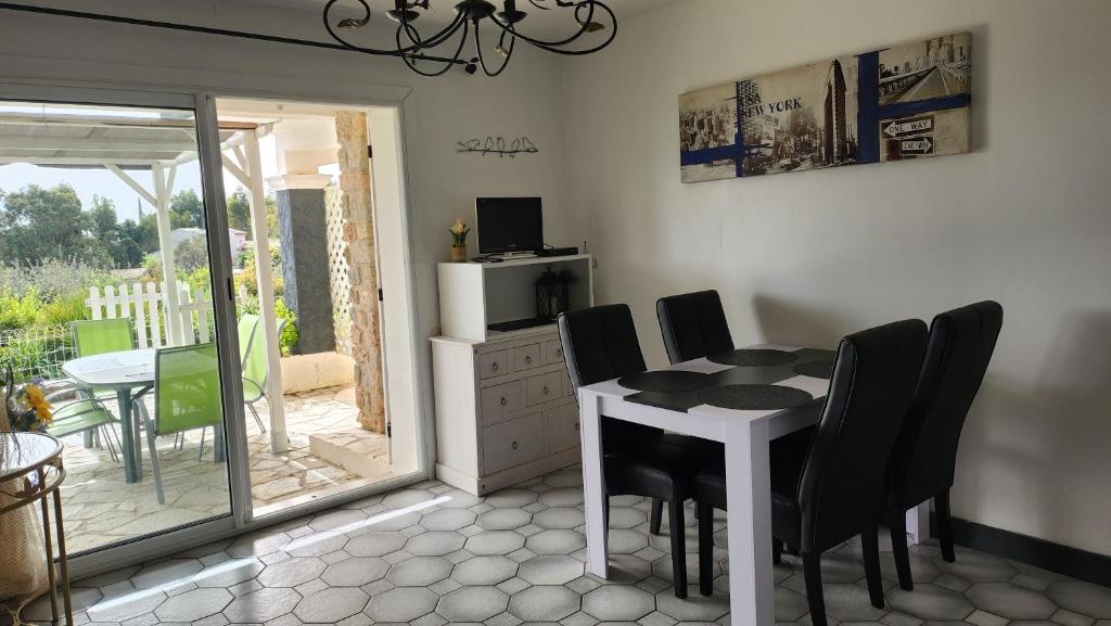 une salle à manger avec une table blanche et des chaises noires dans l'établissement T3 .Vue.jardin Terrasse Parking., à Carqueiranne