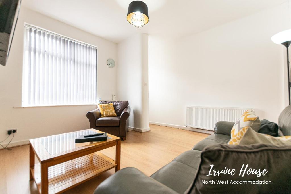 a living room with a couch and a table at Irvine Contractor Accommodation in Leigh