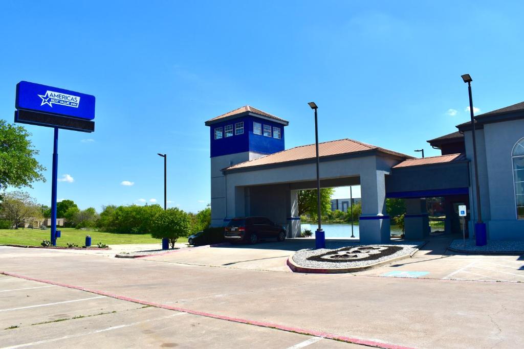 a gas station with a car parked in a parking lot at Americas Best Value Inn & Suites Haltom City Ft. Worth in Haltom City