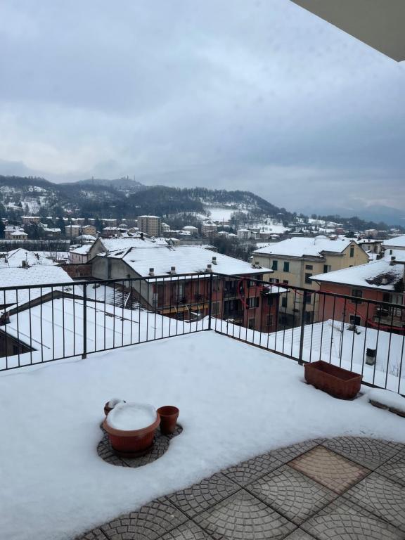 - Balcón cubierto de nieve con vistas a la ciudad en Casa vacanze Abbazia, en Serravalle Scrivia