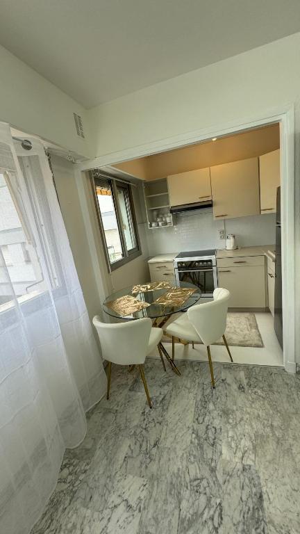 une cuisine avec une table et des chaises dans une pièce dans l'établissement VIP 66 b, à Cannes
