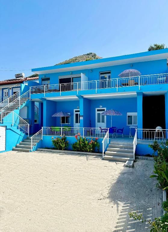 a blue building on the beach at Villa Denny in Borsh