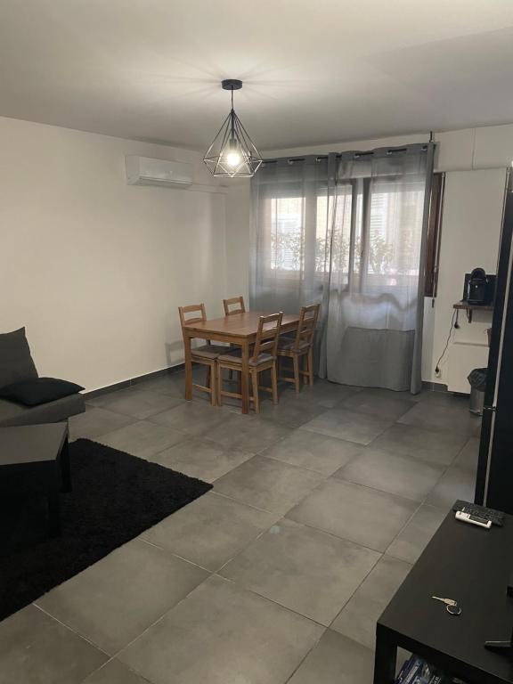 un salon avec une table et des chaises de salle à manger dans l'établissement Appartement neuf et moderne face gare St Charles, à Marseille