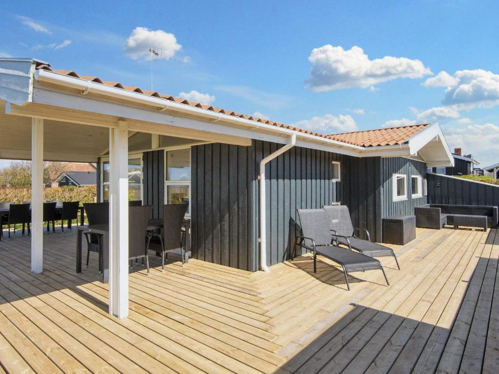 a wooden deck with chairs and a house at 6 person holiday home in Lemvig in Lemvig