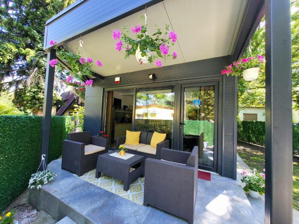 une terrasse avec un canapé, des chaises et des fleurs dans l'établissement Dream Lake, à Palić