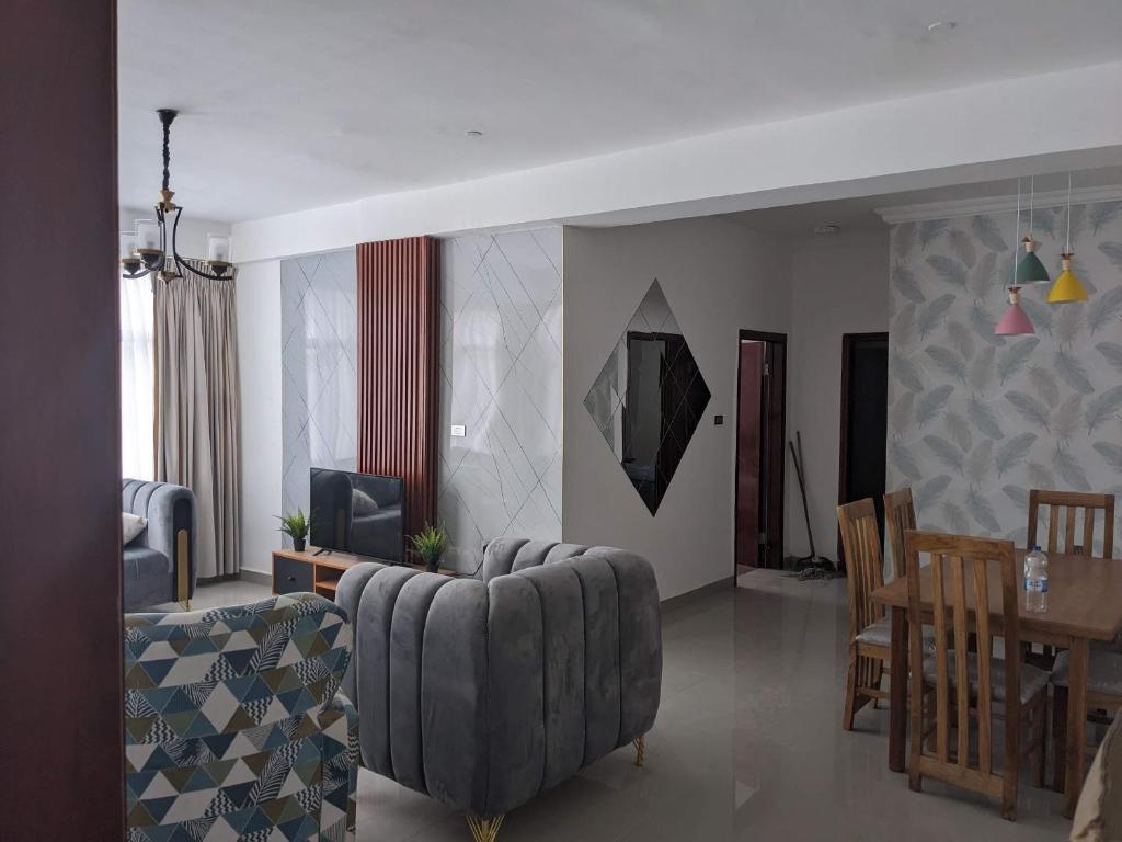 a living room with a couch and a dining room at Casa Feliz - Stylish 2 Bedroom Apartment in Addis Ababa