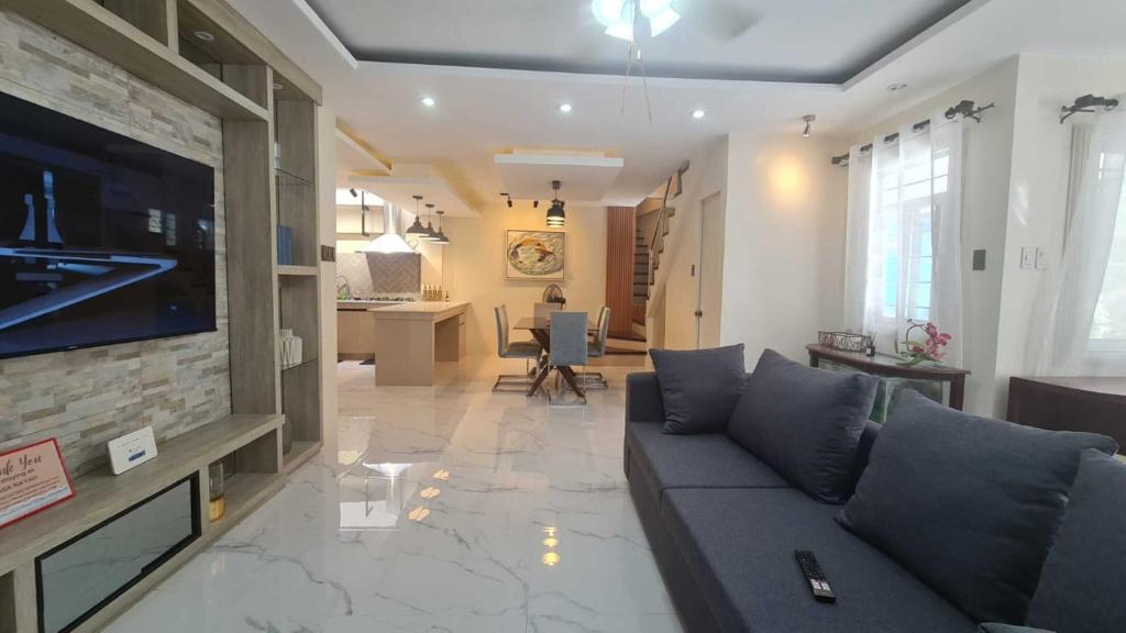 uma sala de estar com um sofá e uma televisão de ecrã plano em Casa Nayah em Cebu