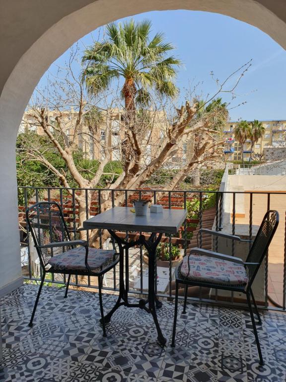 a table and chairs on a balcony with a palm tree at Hostal Mi Campaña in Denia