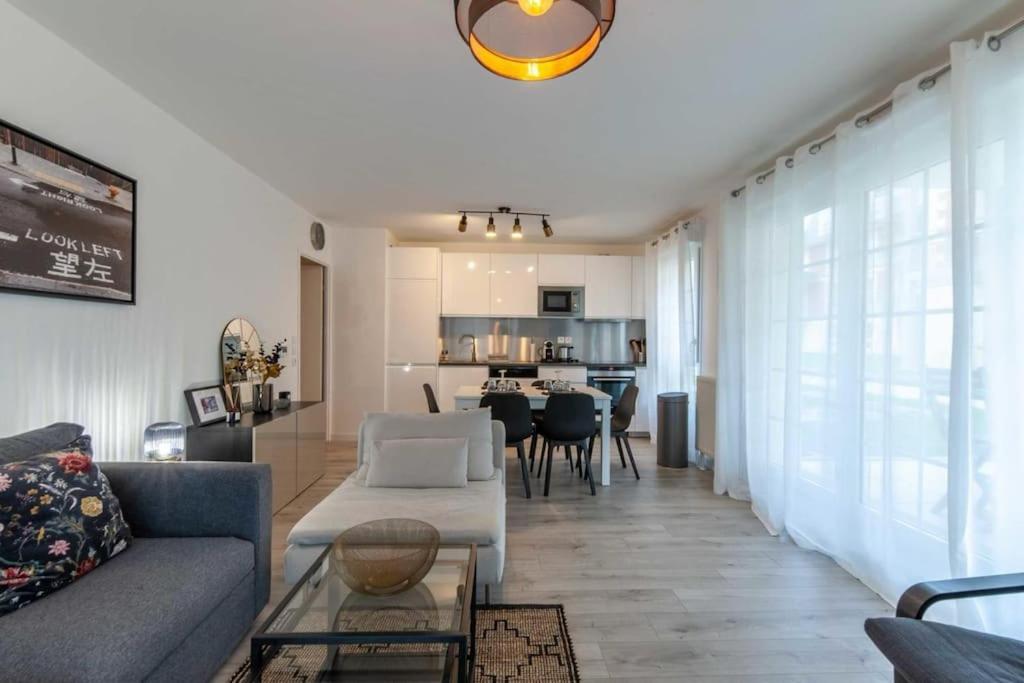a living room with a couch and a table at Appartement Cosy Rez de jardin in Bénerville-sur-Mer