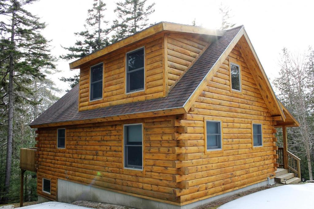 una cabaña de madera con techo de gambrel en Log Cabin on Saltwater Cove, en Ellsworth