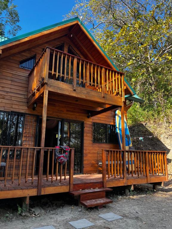 Cabaña de madera con terraza grande y tobogán en Playa Carao en Paquera