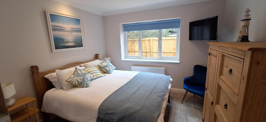 a bedroom with a bed and a tv and a window at The Hollies in Briston