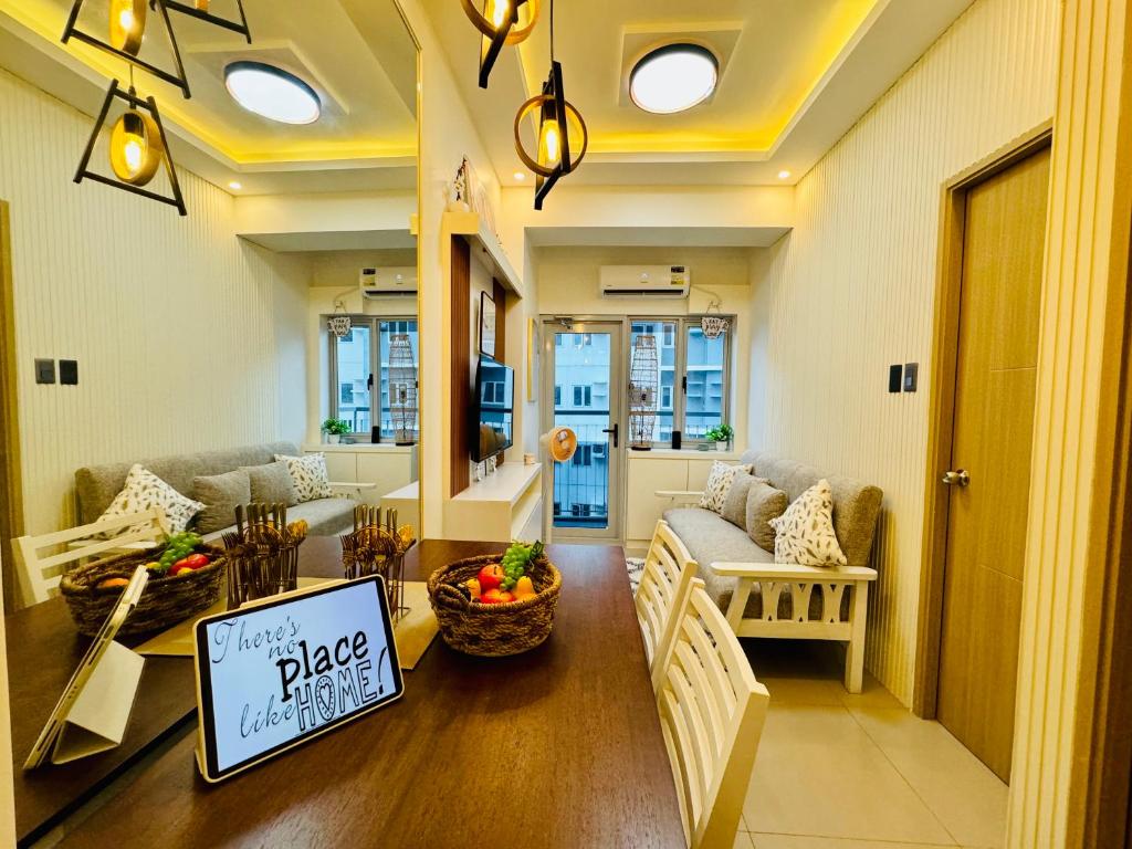 a living room with a couch and a table with a sign at SMDC Vine Residences Condo in Manila