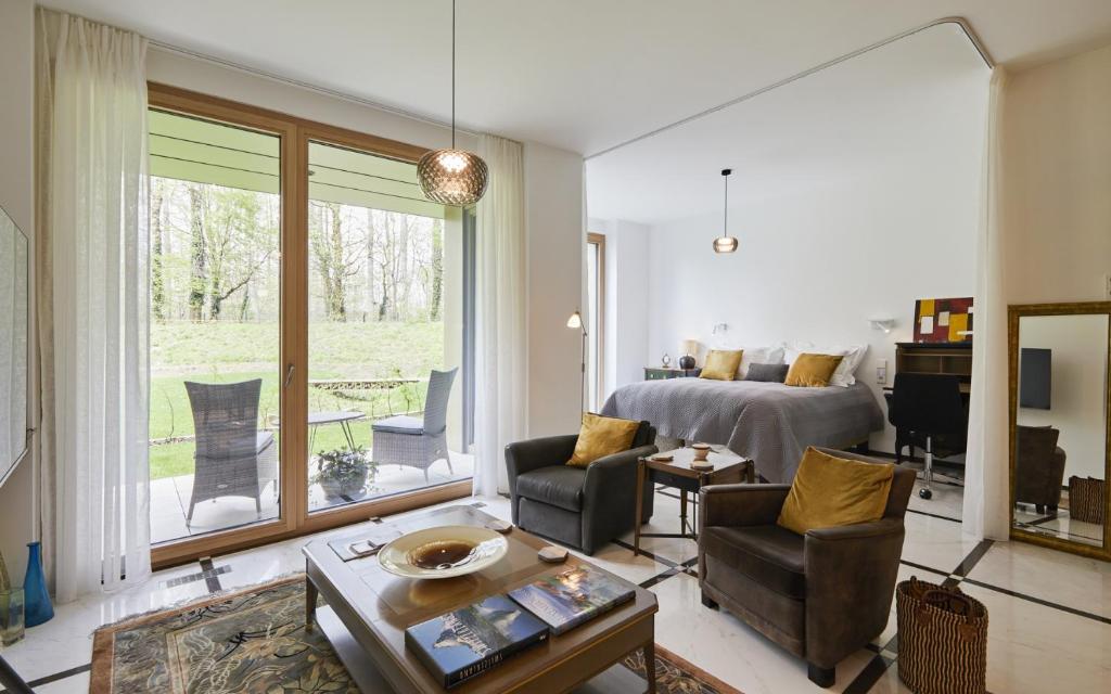 um quarto com uma cama e uma sala de estar em The Executive Residence - Kirchberg em Luxemburgo
