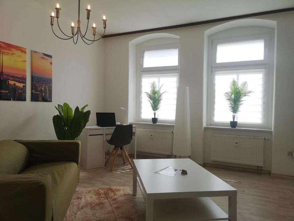 a living room with two windows and a coffee table at Bischofswerda Ferienwohnung Familienfreundlich Seniorengerecht in Bischofswerda