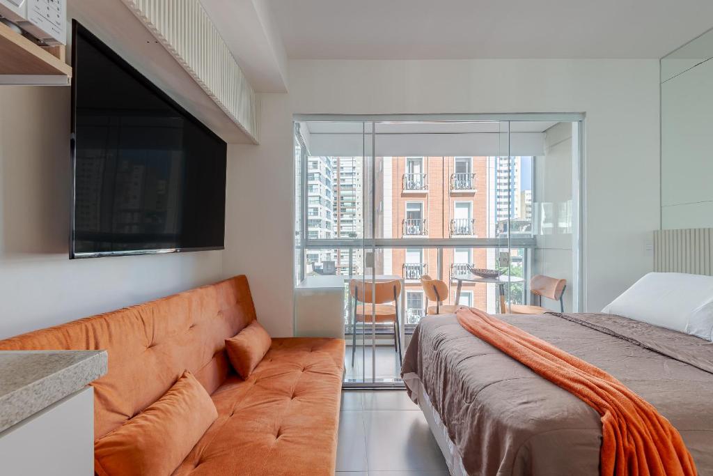 een slaapkamer met een bank en een groot raam bij Apartamento novo e completo próximo a paulista in Sao Paulo
