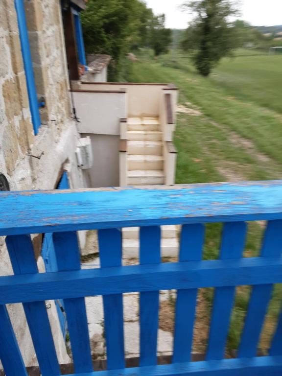 um banco azul sentado em cima de uma varanda em La Graule Old Farmhouse Studio 1 room em Saint-Colomb-de-Lauzun