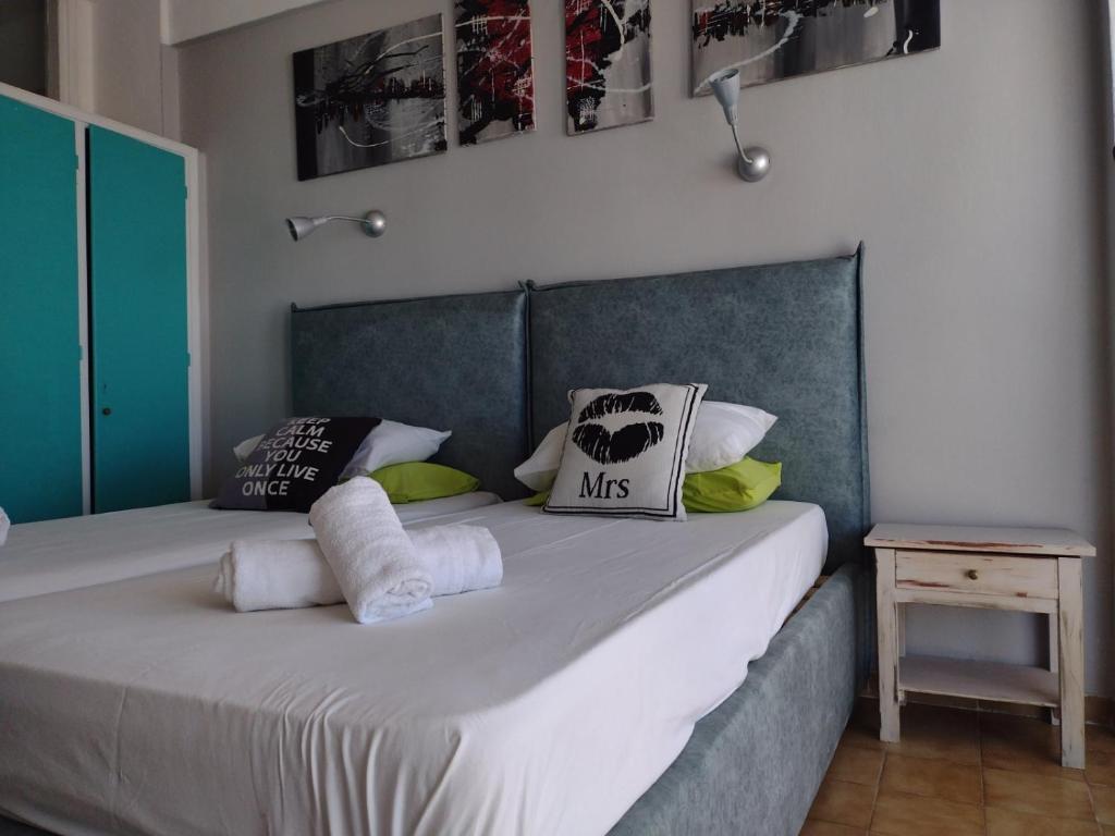 um quarto com uma cama grande com lençóis brancos e almofadas em Art Studios Benitses em Benitses