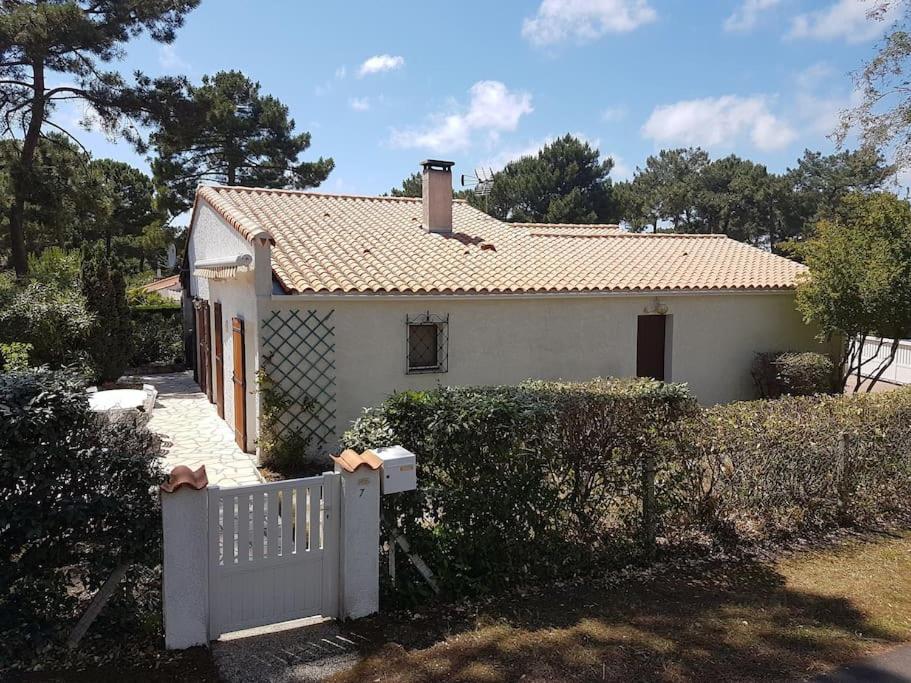 une petite maison blanche avec une clôture blanche dans l'établissement Maison La Palmyre, aux Mathes