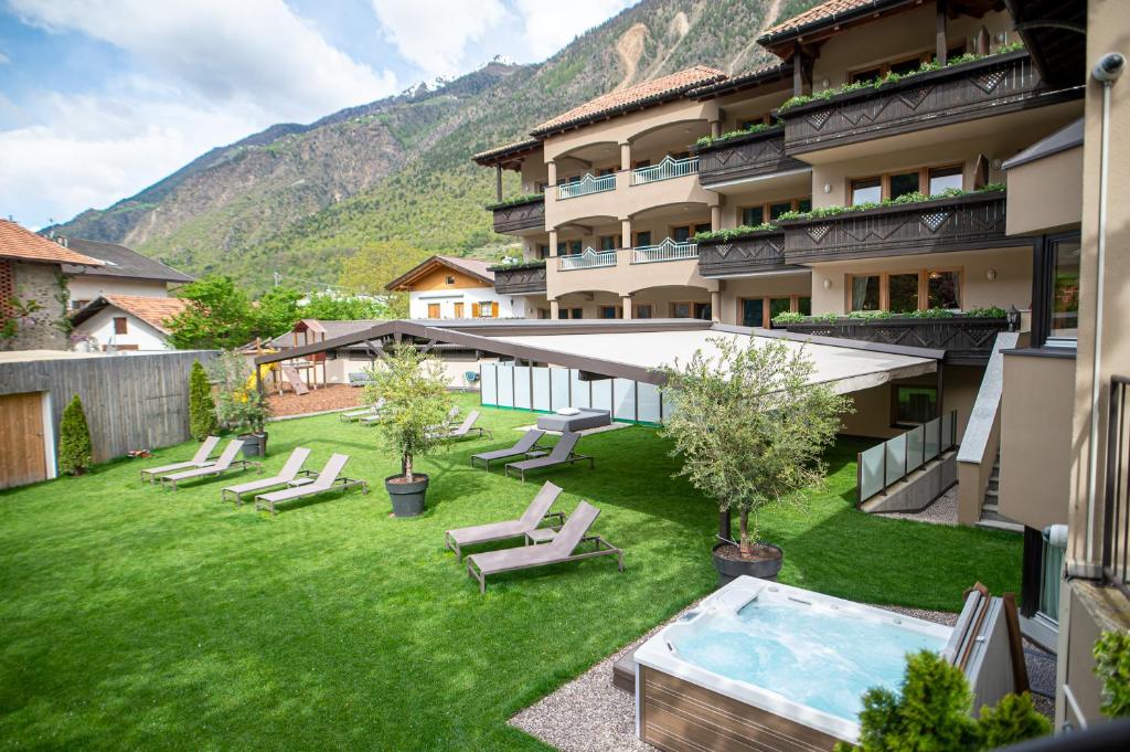 een hotel met een tuin met stoelen en een zwembad bij Hotel Kesslwirt in Ciardes