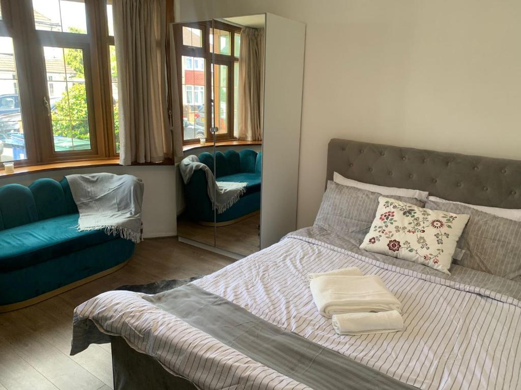 1 dormitorio con 1 cama y 1 sofá azul en mayfair en Northolt