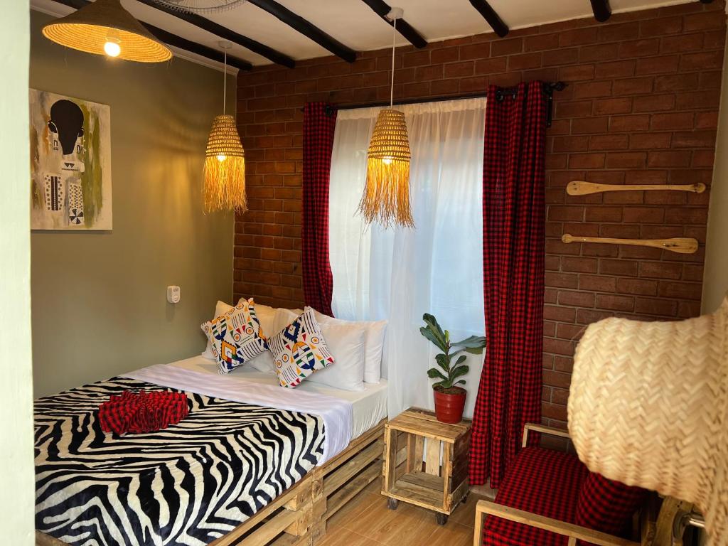 sypialnia z łóżkiem z poduszkami i oknem w obiekcie Swahili Villa w mieście Arusza