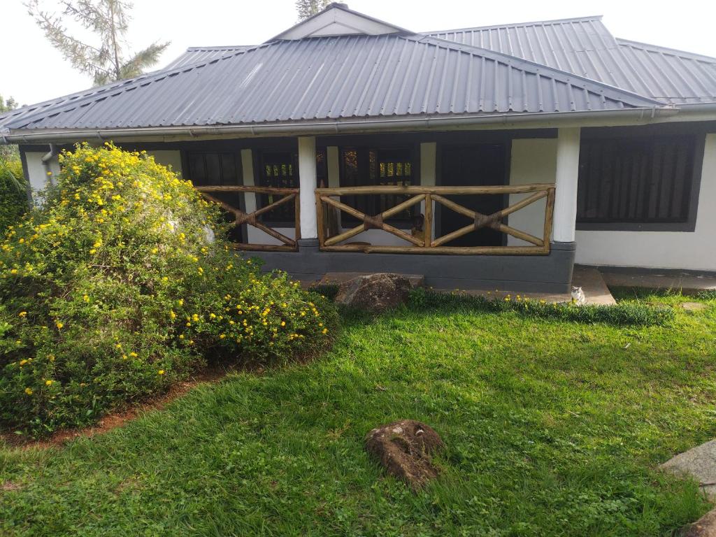 a small house with a black roof and a yard at Precious Home stays in Maragoli