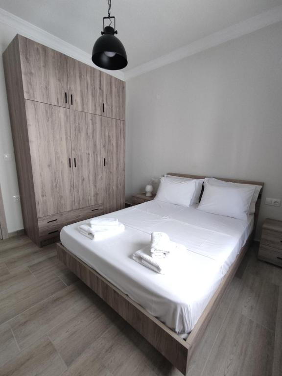 a bedroom with a large bed and a wooden cabinet at Antigoni's apartments in Katerini