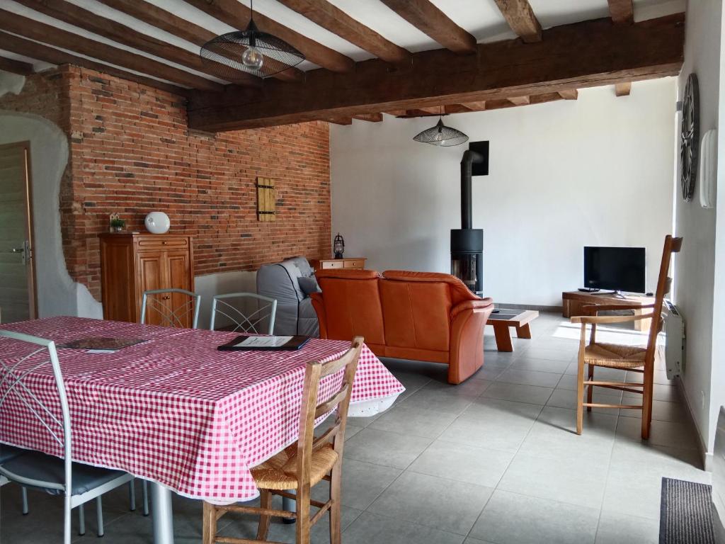 a dining room and living room with a table and chairs at Les gîtes de Camarel in La Plaine
