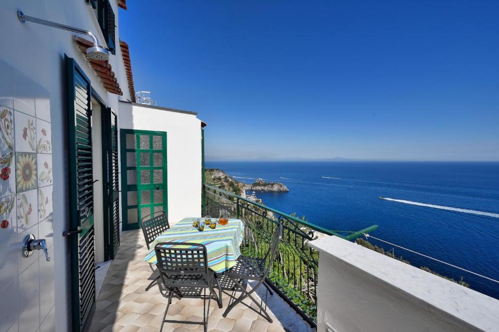 ein Tisch und Stühle auf einem Balkon mit Blick auf den Ozean in der Unterkunft Casa Marianna in Conca dei Marini
