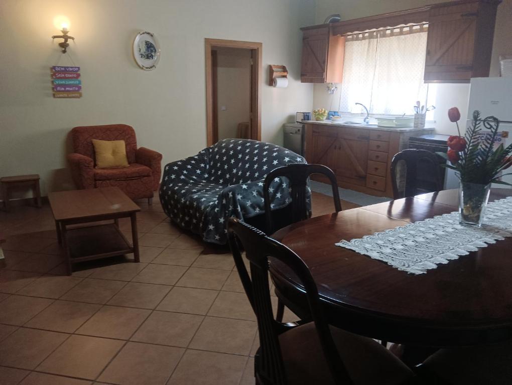 een keuken en een woonkamer met een tafel en een bank bij Cantinho da Susy in Golegã