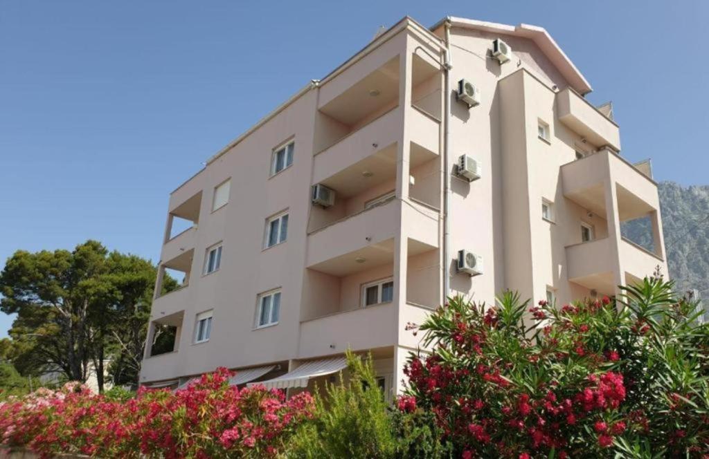 un condominio bianco con fiori di fronte di SARITA Apartments 1 a Makarska
