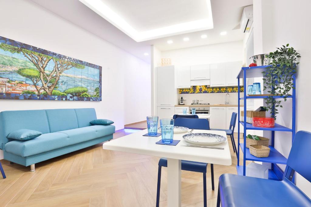 - un salon avec une table et un canapé bleu dans l'établissement Casa NordOvest Cheerful Apartment, à Salerne