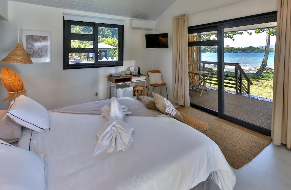 1 dormitorio con cama y vistas al agua en Sublime Tahiti Beach Retreat, en Mataiea