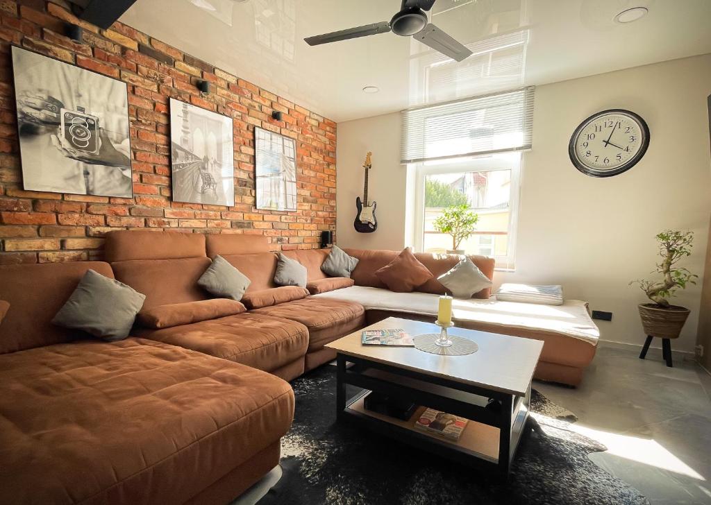 a living room with a couch and a brick wall at Design Loft Herford in Herford