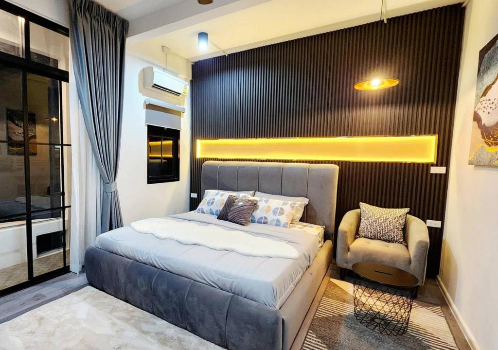 ein Schlafzimmer mit einem Bett und einem Stuhl in der Unterkunft LS 2 Lasalle House,bts,Suvarnabhumi ,mega bangna in Ban Khlong Samrong