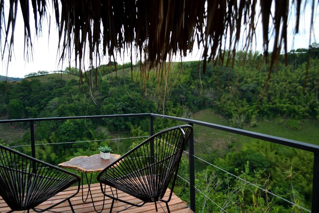 a table and chairs sitting on a deck with a view at Encanto Toscano in Quimbaya