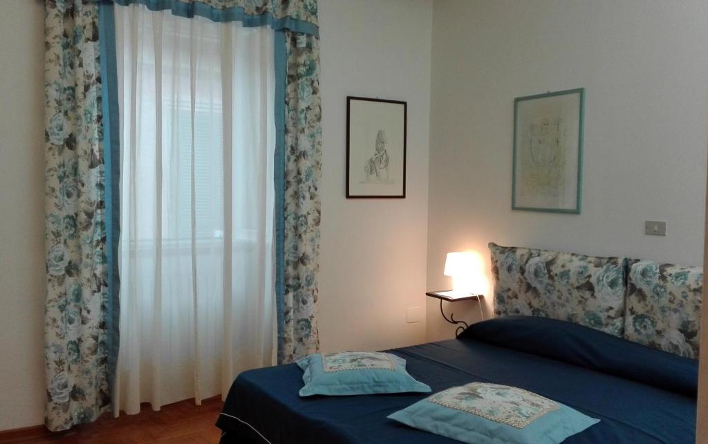 a bedroom with a bed and a window with curtains at La grangia in Ferentino