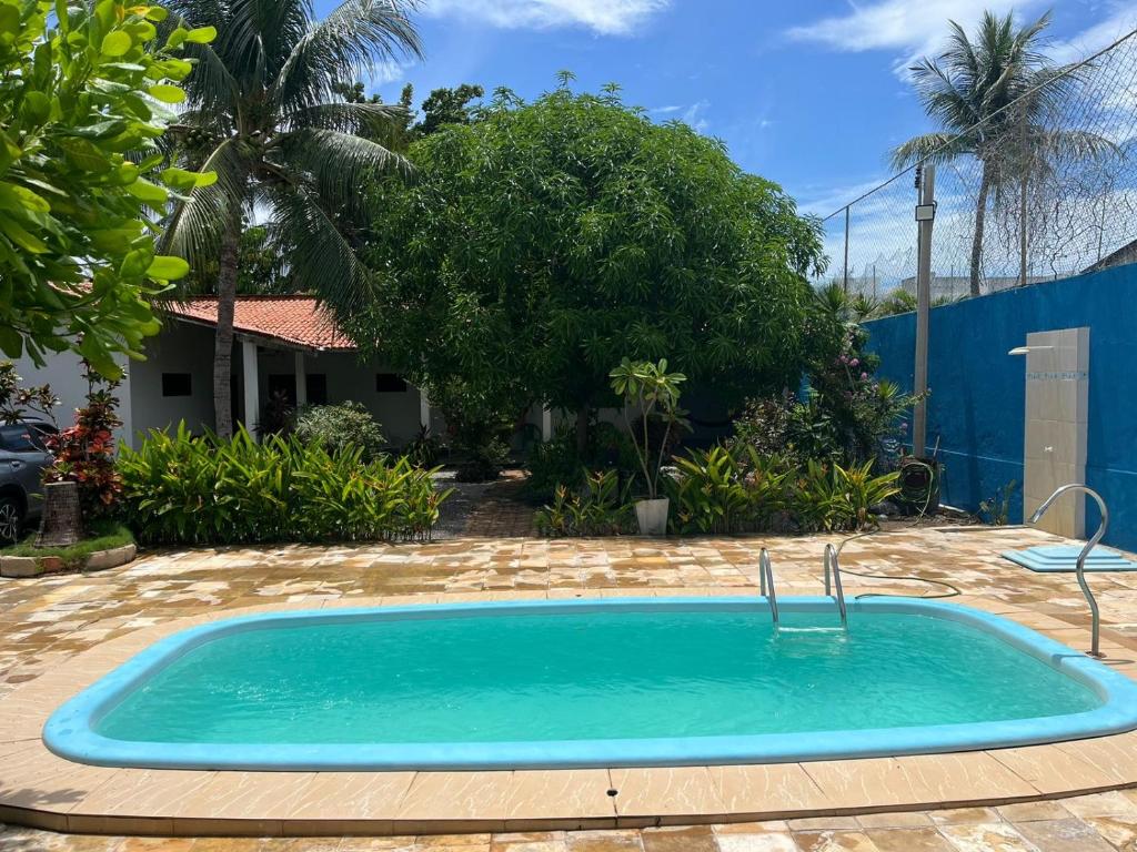 una piscina in un cortile con una casa di Casa Barra de São miguel a Barra de São Miguel