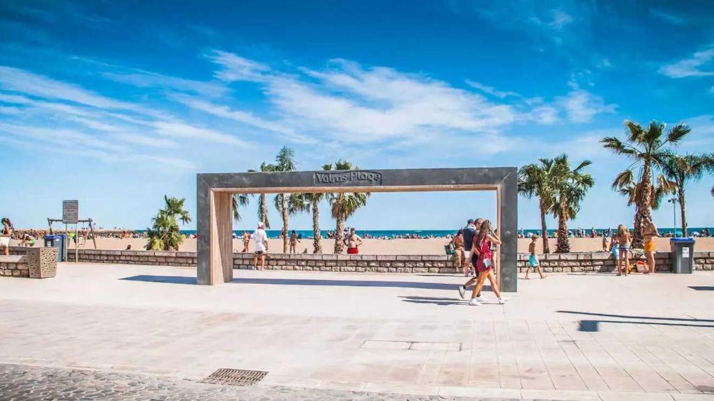 un groupe de personnes marchant devant la plage dans l'établissement VALRAS - Studio avec parking fermé 50m de la plage, à Valras-Plage