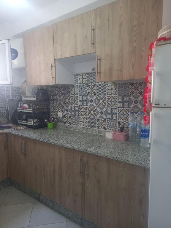 - une cuisine avec des placards en bois et un comptoir dans l'établissement résidence miftah sahile, à Zemmour Touirza