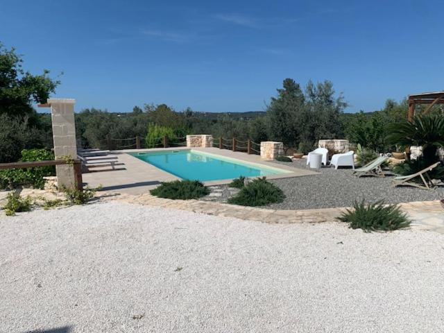 a swimming pool in the middle of a yard at Trulli Santa Maria Odegitria Relais in Ostuni