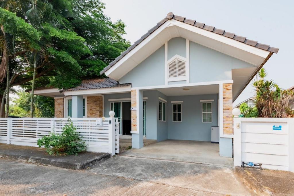 a house with a white fence at บ้านม่วนใจ๋กรีนวิว in Ban Wang Pong