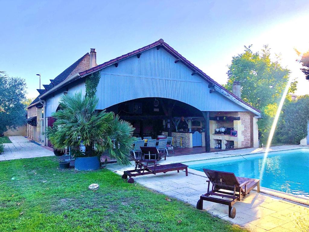 una casa con piscina frente a ella en Maison de vacances tout confort, piscine privée & équipements uniques, DORDOGNE, en Lamonzie-Saint-Martin