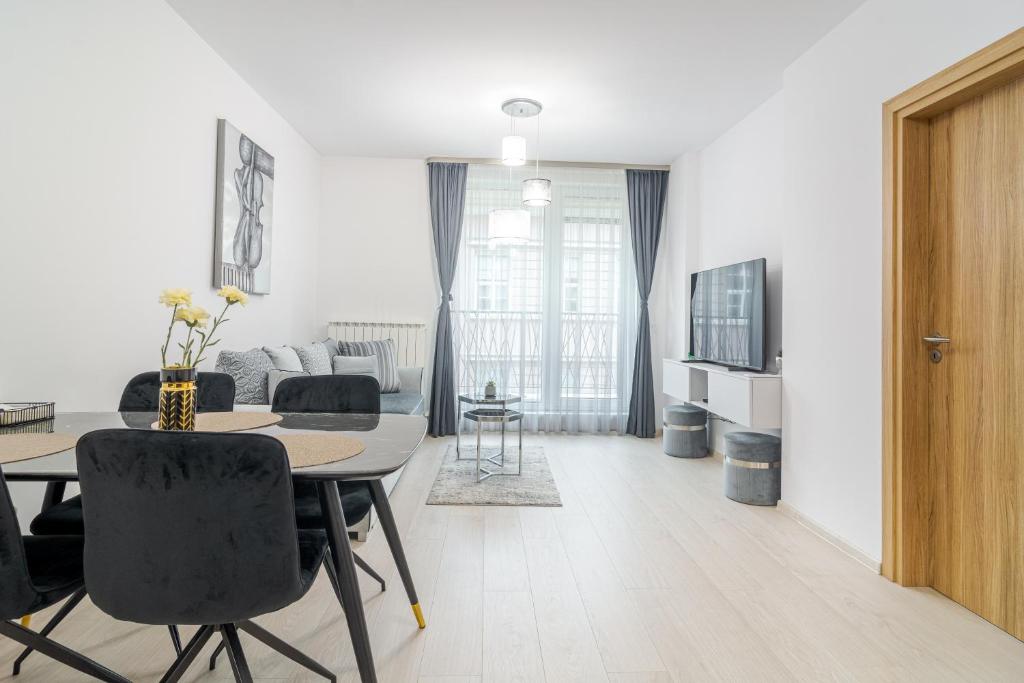 Paris luxury top centre Apt with office space في صوفيا: غرفة معيشة بيضاء مع طاولة وأريكة