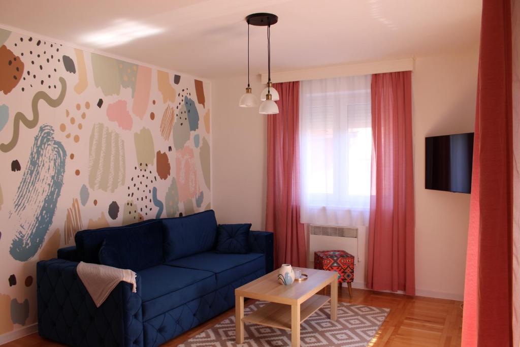 sala de estar con sofá azul y mesa en PARK Apartment en Bijeljina