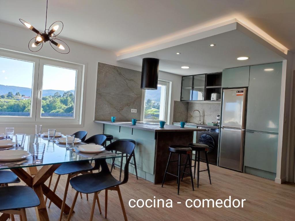 a kitchen and dining room with a table and chairs at O Paseo, 5 estrellas. in Puentedeume