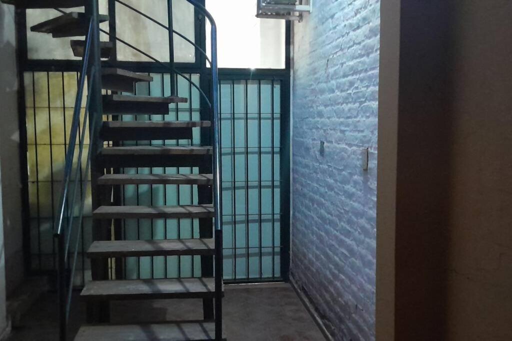 a spiral staircase in a room with a brick wall at Apartamento en Mendoza in La Cieneguita