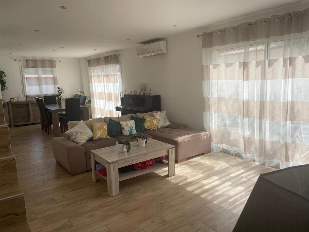 un salon avec un canapé et une table dans l'établissement Maison lumineuse à Porto-Vecchio, à Porto-Vecchio